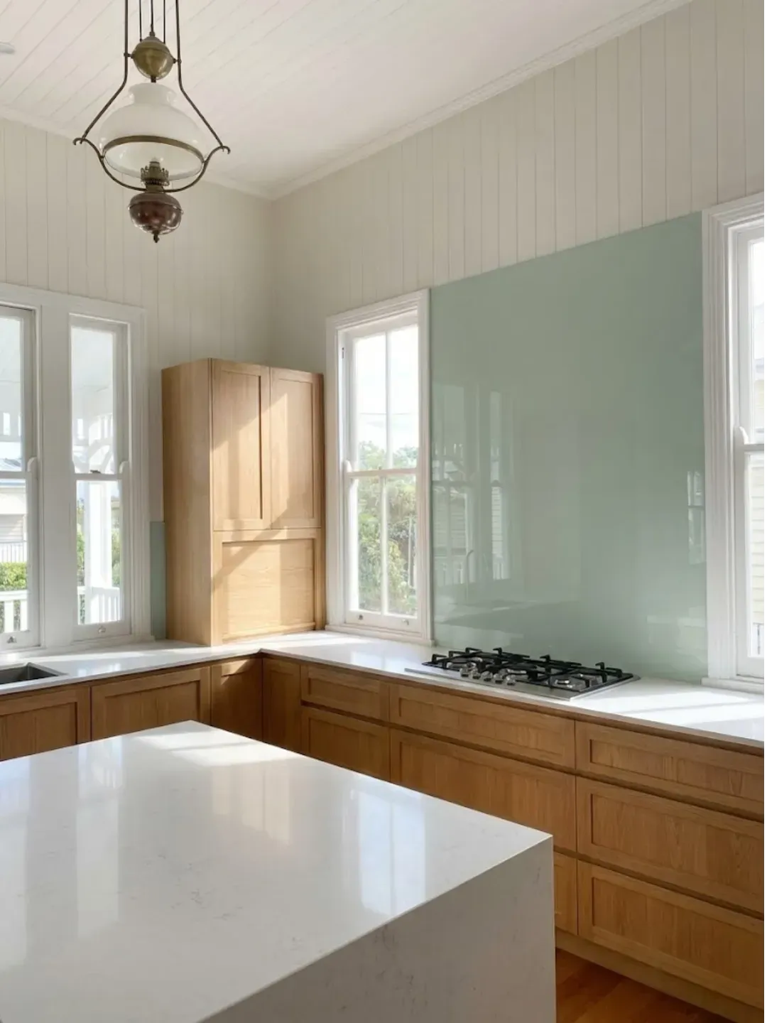 Custom coloured glass splashbacks west end with precision cut-outs for power points and millimetre-perfect fit.
